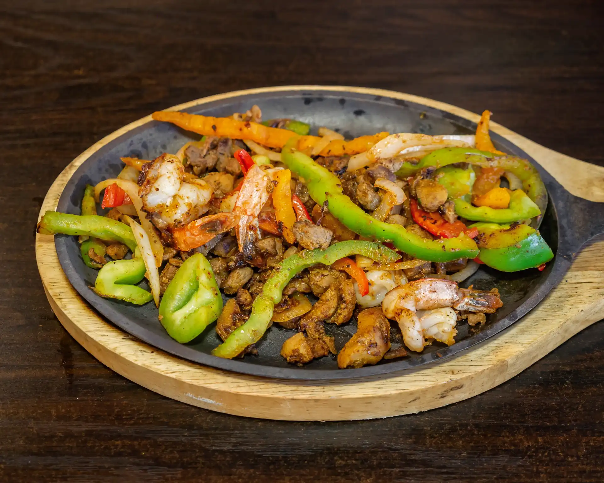 Chicken Fajitas - Sizzling chicken fajitas served with bell peppers, onions, rice, beans, and tortillas.